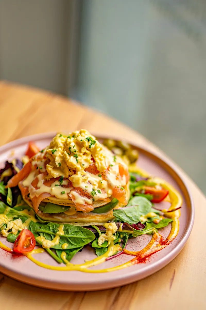 Pancakes salés garnis de saumon, d’œufs et de salade.